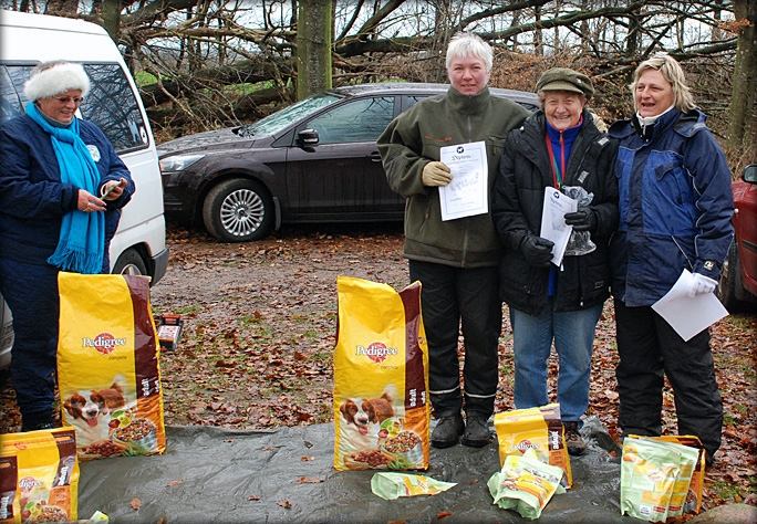 praemier_0369.jpg - Præmieoverrækkelse søndag - en lidt kold affære. Vi skutter os og kryber sammen for at få varmen. Marie-Louise Lakjer til venstre havde snakket godt for Pedigree Pal og skaffet sponsorpræmier i sidste øjeblik. Så hun fik da også æren af at dele dem ud.