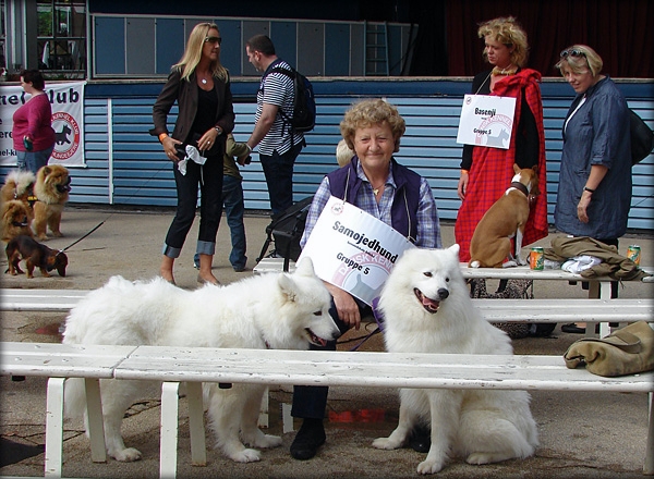 ankommet.jpg - Vel ankommet, påtaget smil og med skilt om halsen forsøger vi at lukke ørerne for en drønende lydprøve fra scenen med sangen "Who let the dogs out.."